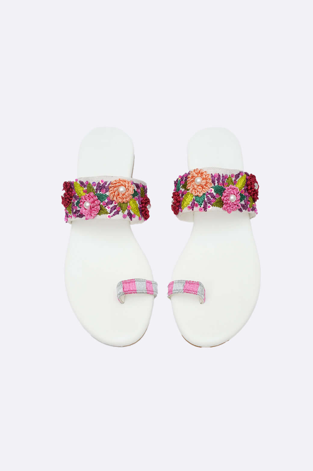 Flora Muse handcrafted white leather flats with vibrant floral embroidery and pearl embellishments, elegant ladies footwear from UAE.